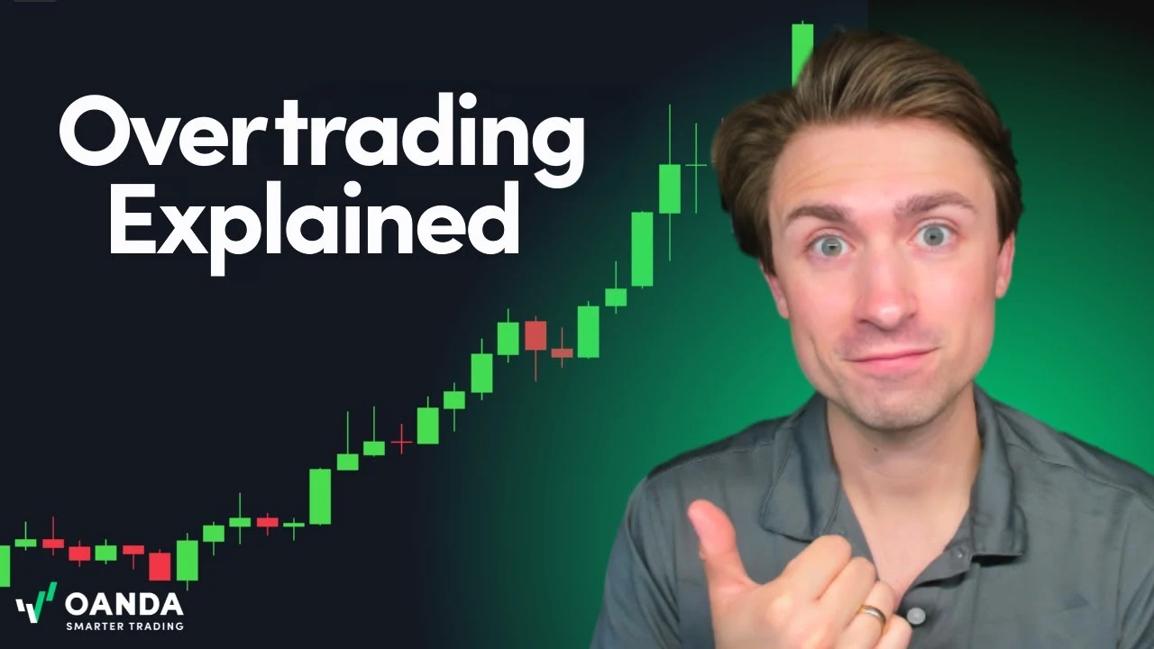 OANDA educational video thumbnail with bold white text reading 'Overtrading Explained'. An expressive presenter points his thumb next to a steeply rising green and red financial candlestick chart.